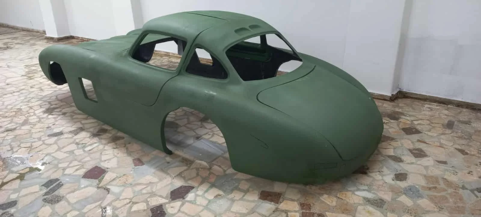 Bare fiberglass replica body showing the roofline and integrated wheel-arch eyebrows